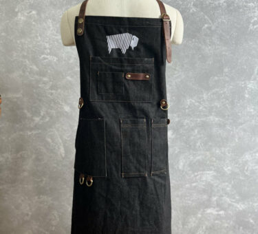 BBQ apron displayed on a fashion mannequin, showcasing its design and features.