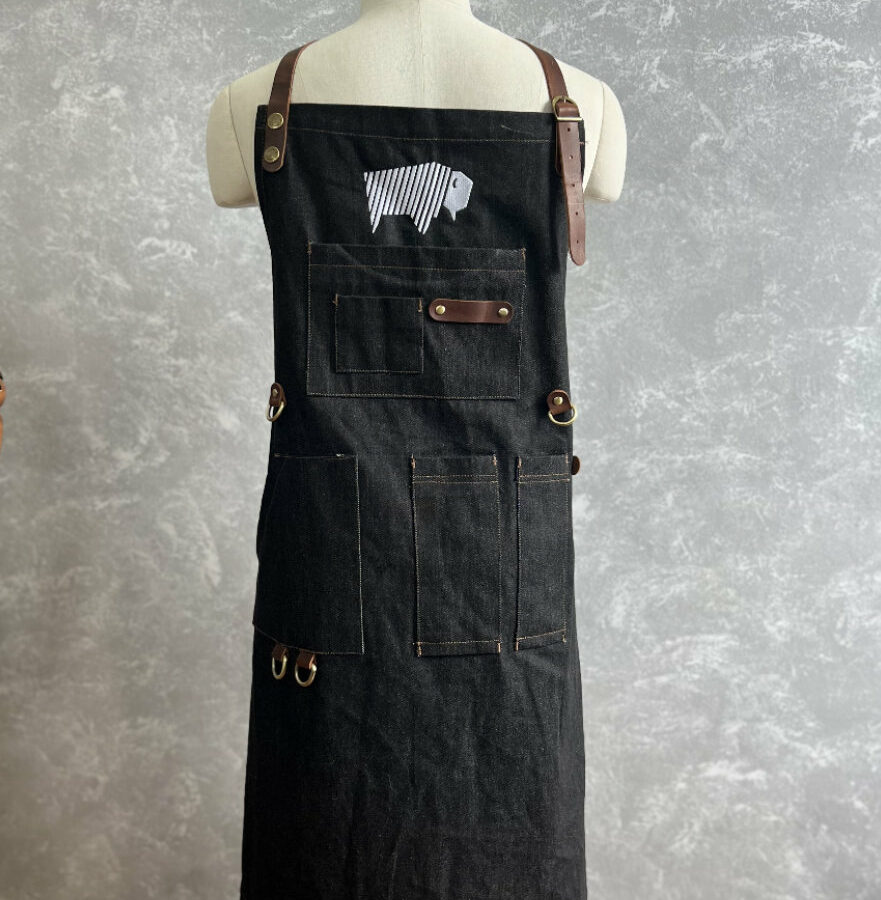 BBQ apron displayed on a fashion mannequin, showcasing its design and features.