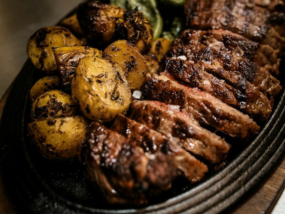 Freshly shredded pulled pork on a wooden serving board