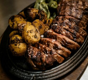Freshly shredded pulled pork on a wooden serving board