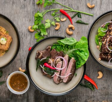 Smoked meats and BBQ food displayed on a natural edge English oak serving board