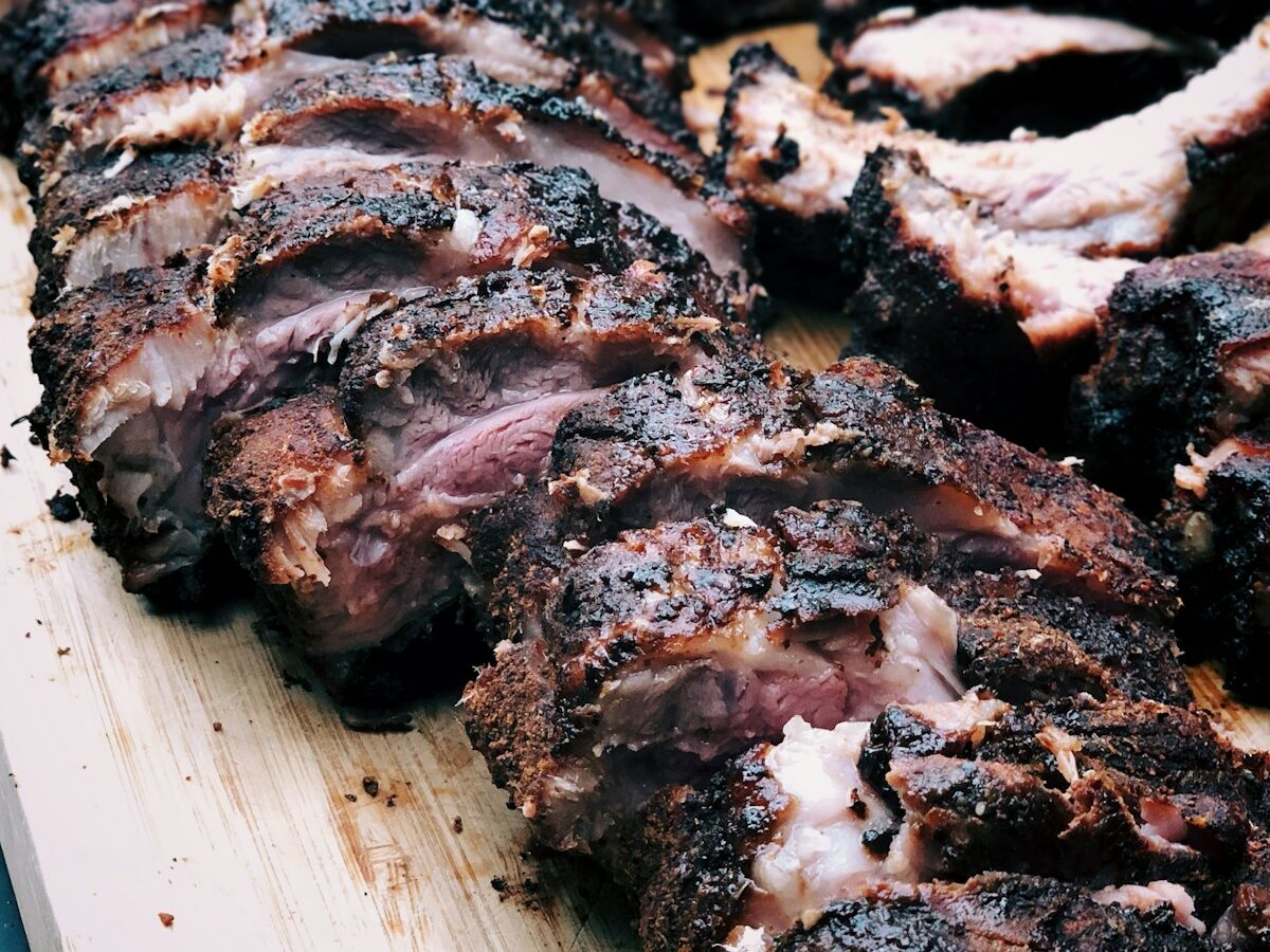 Flat metal skewers with chicken and vegetable kebabs on a charcoal grill